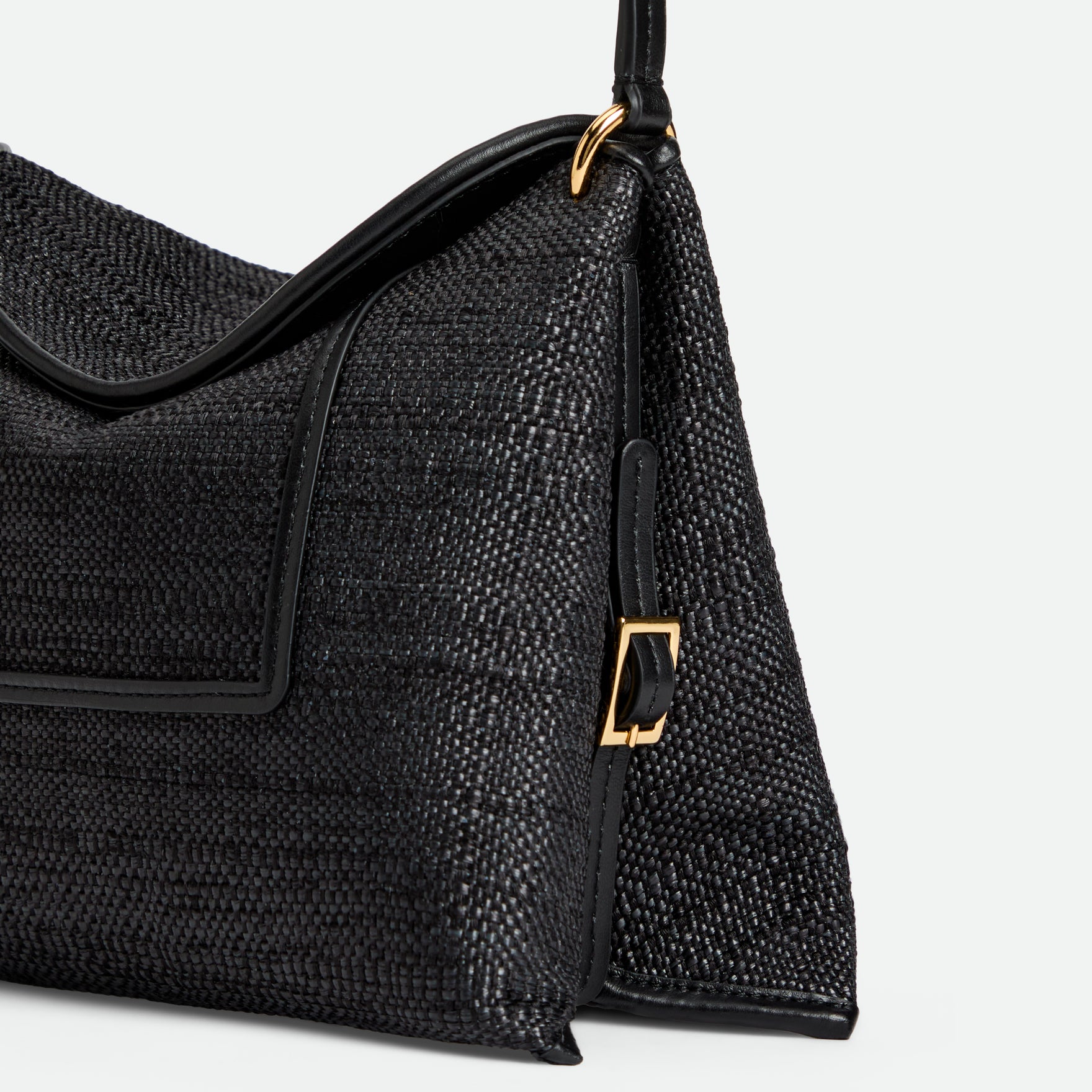 Wandler Penelope Slouch Bag in the color Black Raffia, made from raffia and smooth calf leather with golden hardware and adjustable slim strap, close up shot detailing the buckle and raffia.