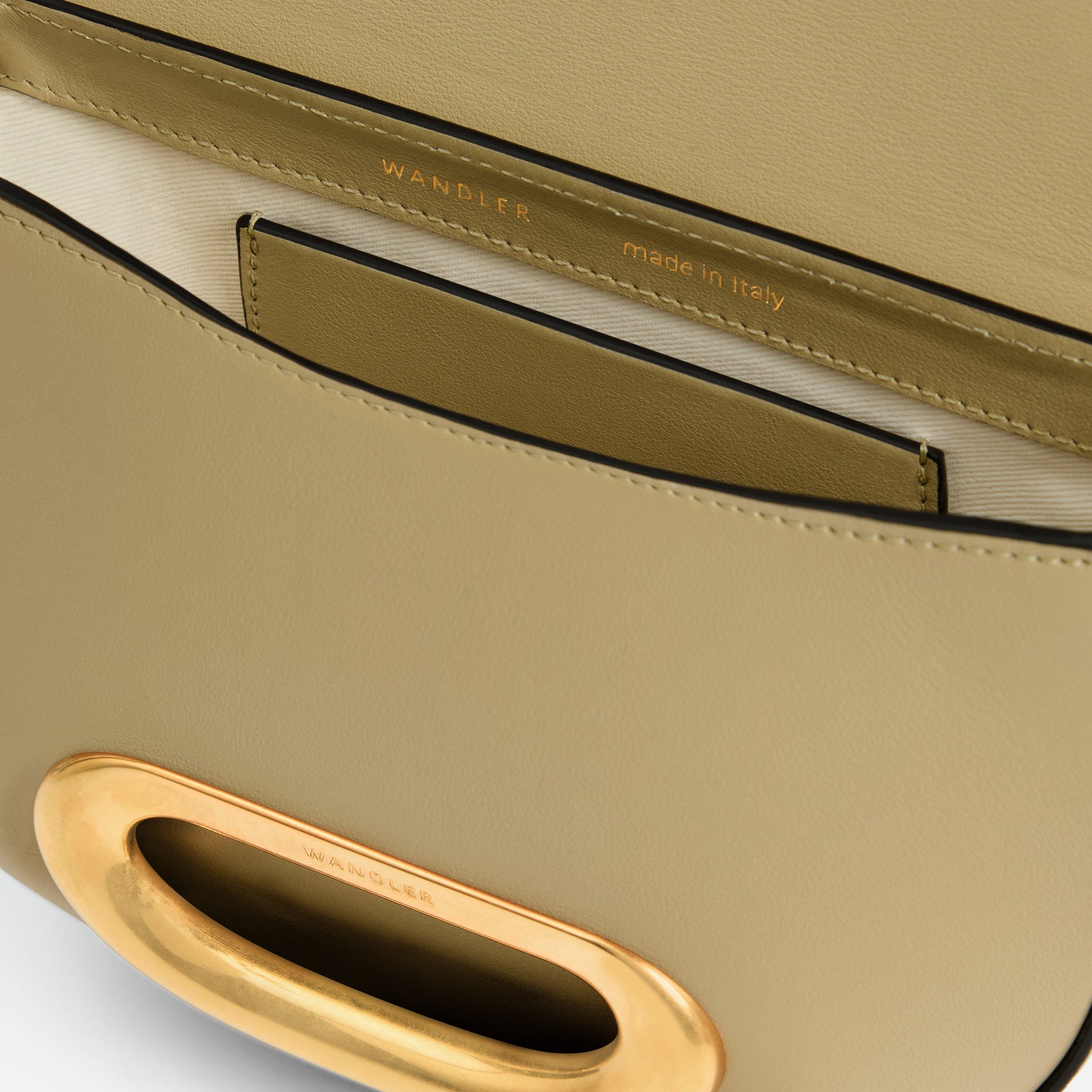 Wandler Veneto Crossbody Small in Peper, dark beige, made from Italian calf leather with golden clasp hardware and structured silhouette, close up detailing the clasp,  leather, with a small glimpse into the inside of the bag. 