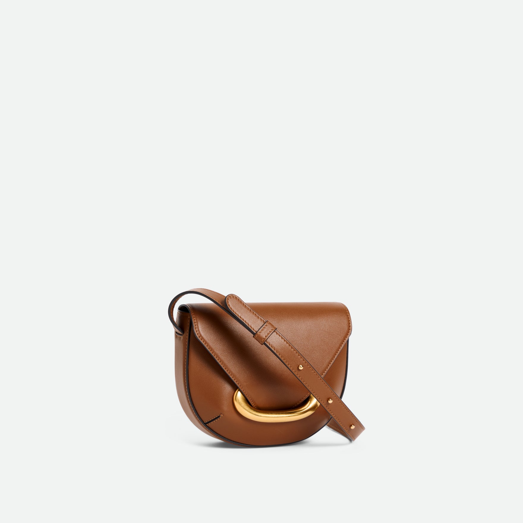 Wandler Veneto Crossbody Small in Saddle, warm brown, made from Italian calf leather with golden clasp hardware and structured silhouette, three quarters angle. 