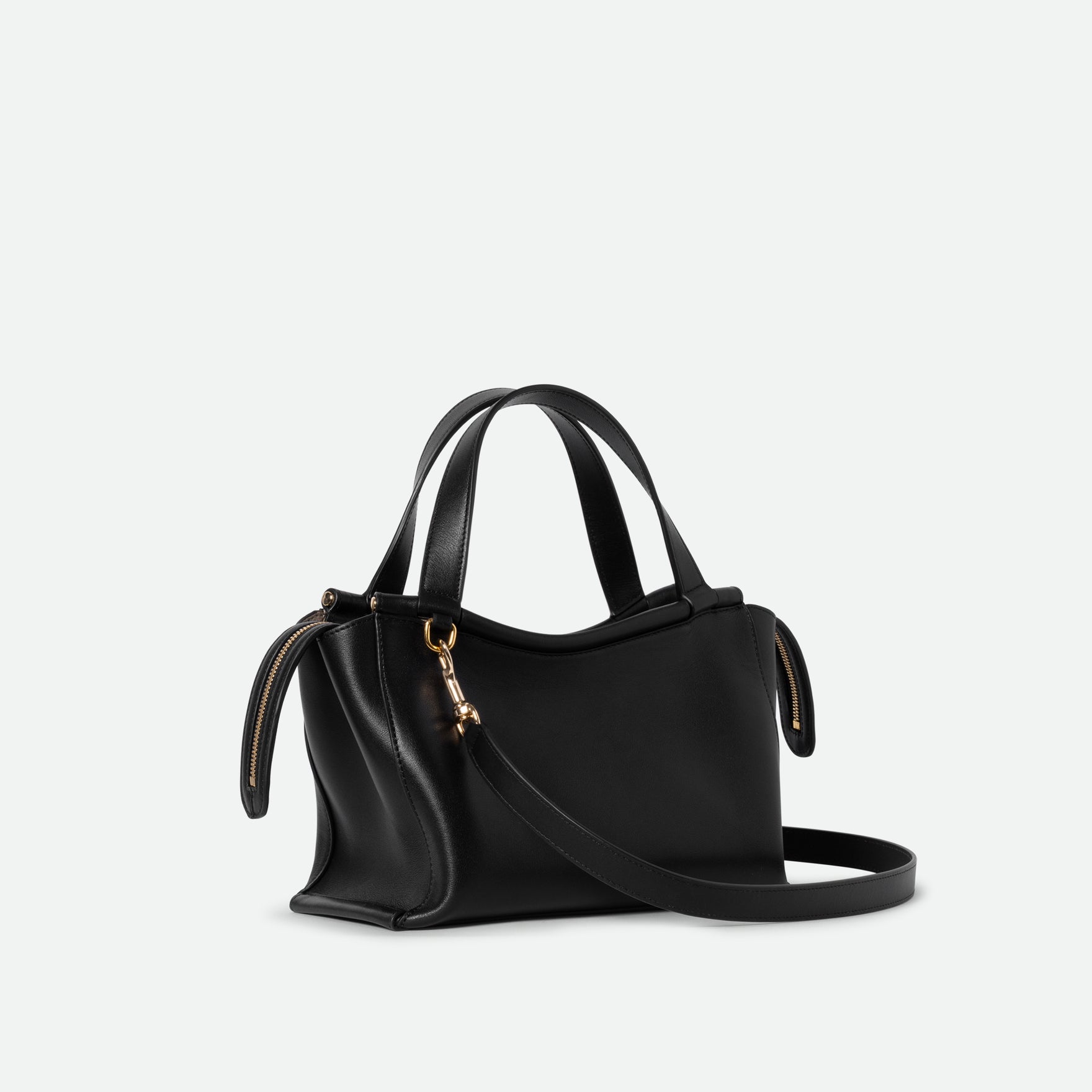 Wandler Ida Bag in the color Black, made from Italian calf leather with golden hardware and sculptural top handle, three quarters view.