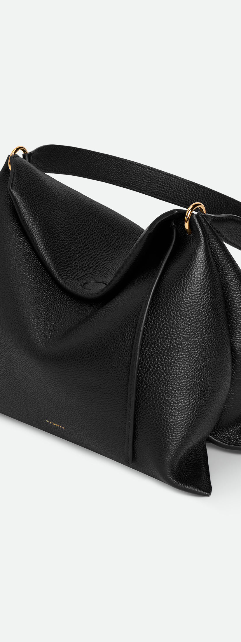 Wandler Penelope Tote Small in the color Black Crust made from calf leather with golden hardware and soft slouchy silhouette, pictured from above, three quarters view.