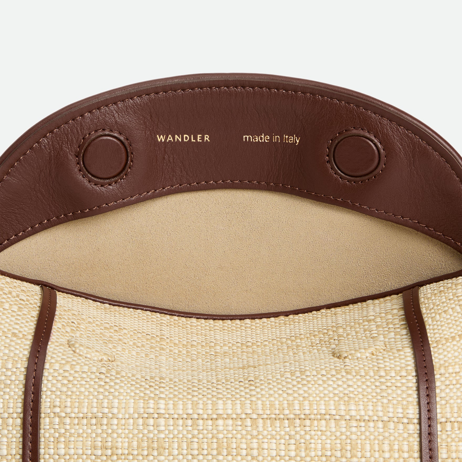 Wandler Penelope Slouch Bag in the color Beige Raffia, made from smooth calf leather with golden hardware and adjustable slim strap, close up picture, bag is pictured from the front with the flap over, detailing the Wandler logo.