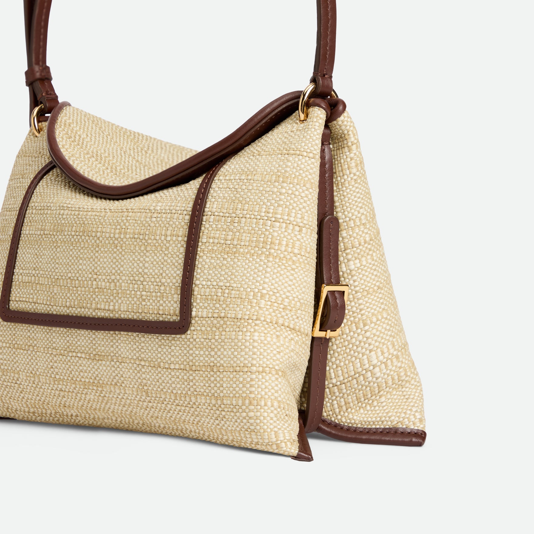 Wandler Penelope Slouch Bag in the color Beige Raffia, made from smooth calf leather with golden hardware and adjustable slim strap, close up detailing buckle and raffia.