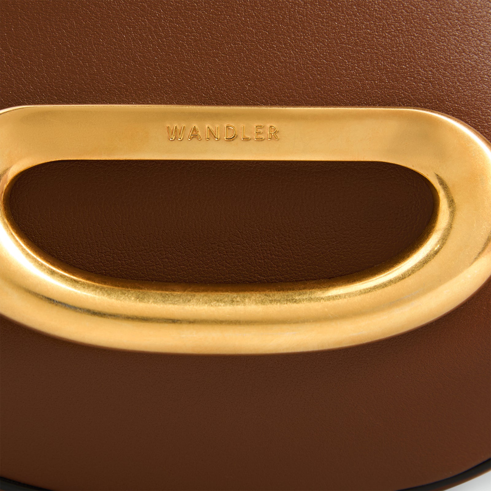 Wandler Veneto Crossbody Small in Saddle, warm brown, made from Italian calf leather with golden clasp hardware and structured silhouette, close up detailing the clasp opening. 