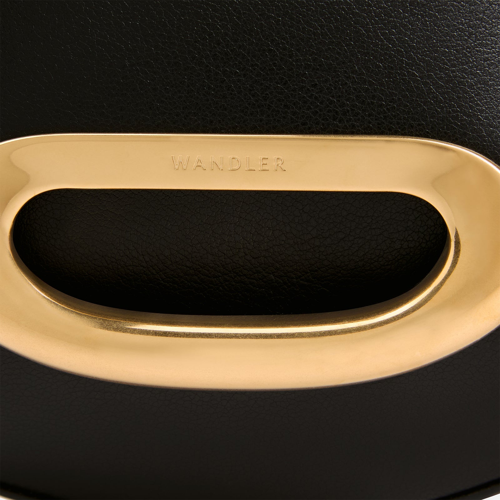 Wandler Veneto Crossbody Small in Black, made from Italian calf leather with golden clasp hardware and structured silhouette, close up detailing the clasp opening. 