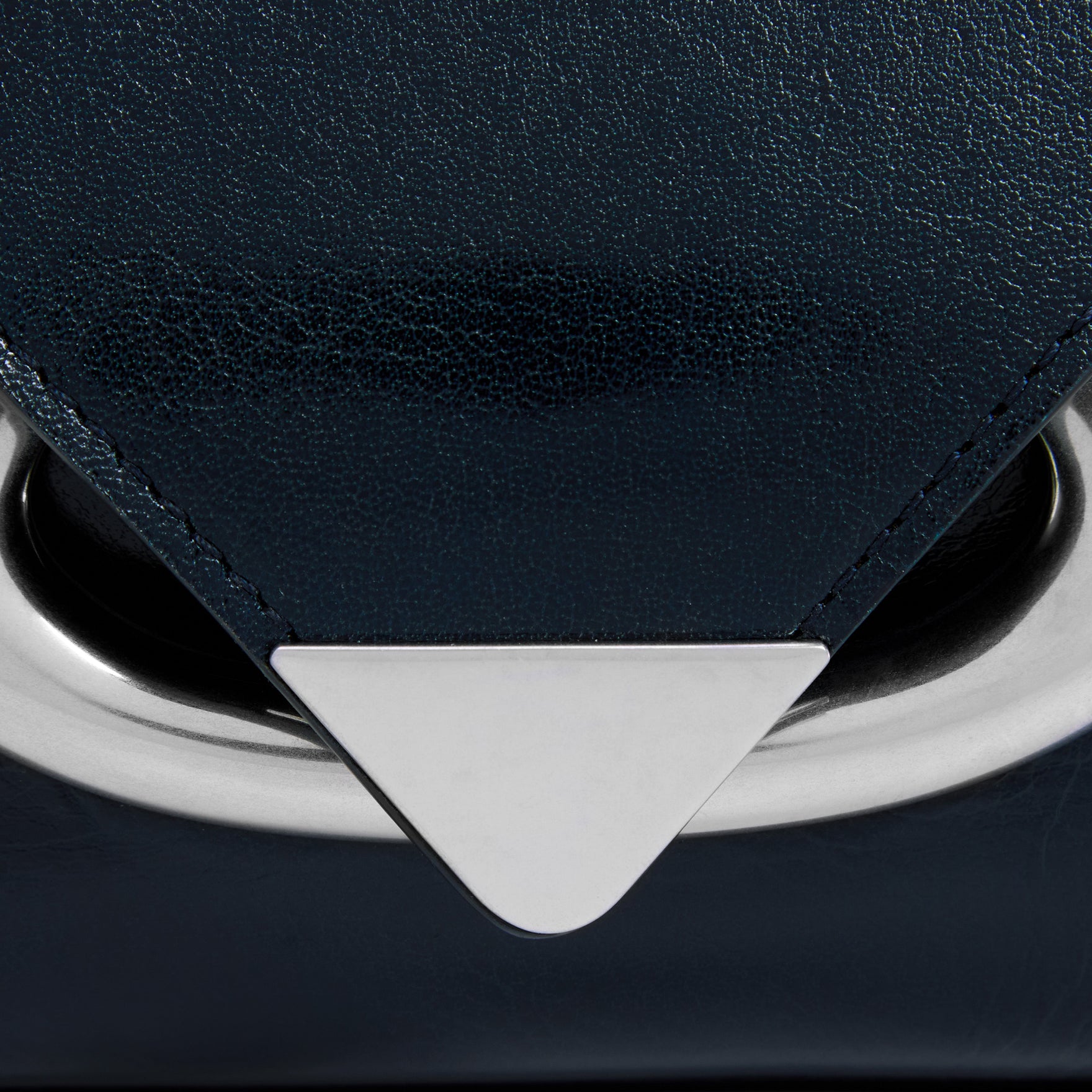 Wandler Veneto Shoulder Bag in the color Orion Glaze, deep dark blue, Italian calf leather with oversized silver clasp hardware and structured silhouette, close up detailing the clasp.