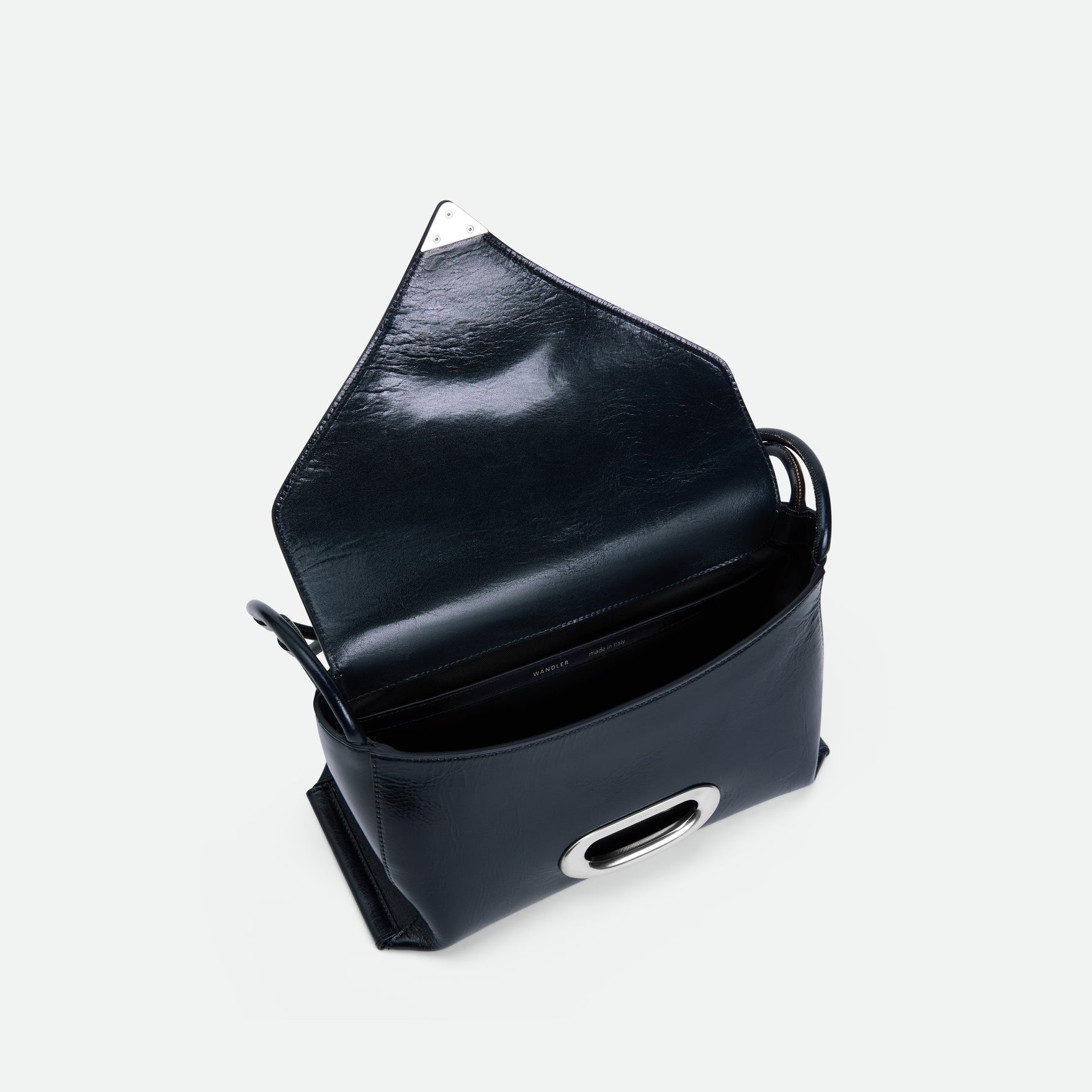 Wandler Veneto Shoulder Bag in the color Orion Glaze, deep dark blue, Italian calf leather with oversized silver clasp hardware and structured silhouette. The bag is pictured from above with the flap open, giving a slight view of the inside of the bag.