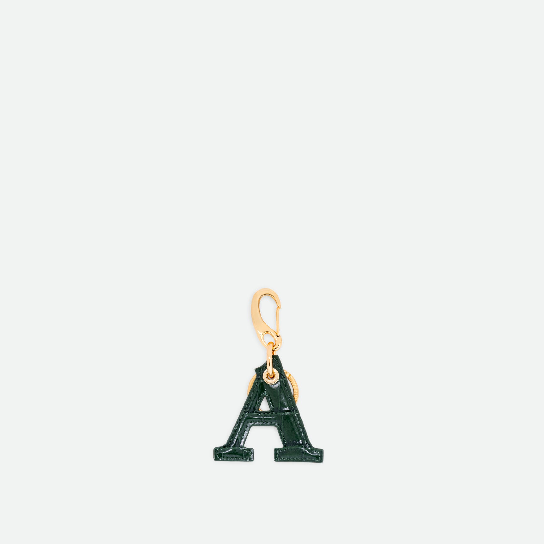 Wandler Bag Charm Letter in the color Olive Croco, green with crocodile print, Letter M, made from brass, lambskin leather with golden hardware, front view.