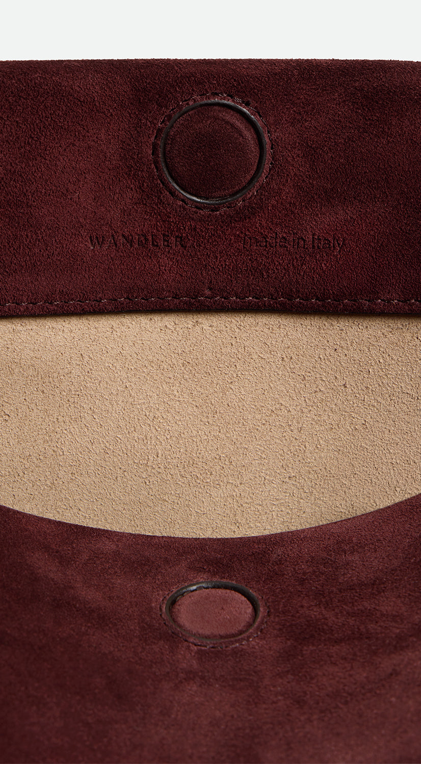 Wandler Penelope Tote Small in the color Acai Suede / Black made from calf leather with golden hardware and soft slouchy silhouette, close up detailing the closure and leather.
