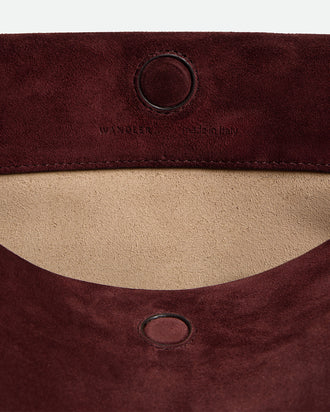 Wandler Penelope Tote Small in the color Acai Suede / Black made from calf leather with golden hardware and soft slouchy silhouette, close up detailing the closure and leather.
