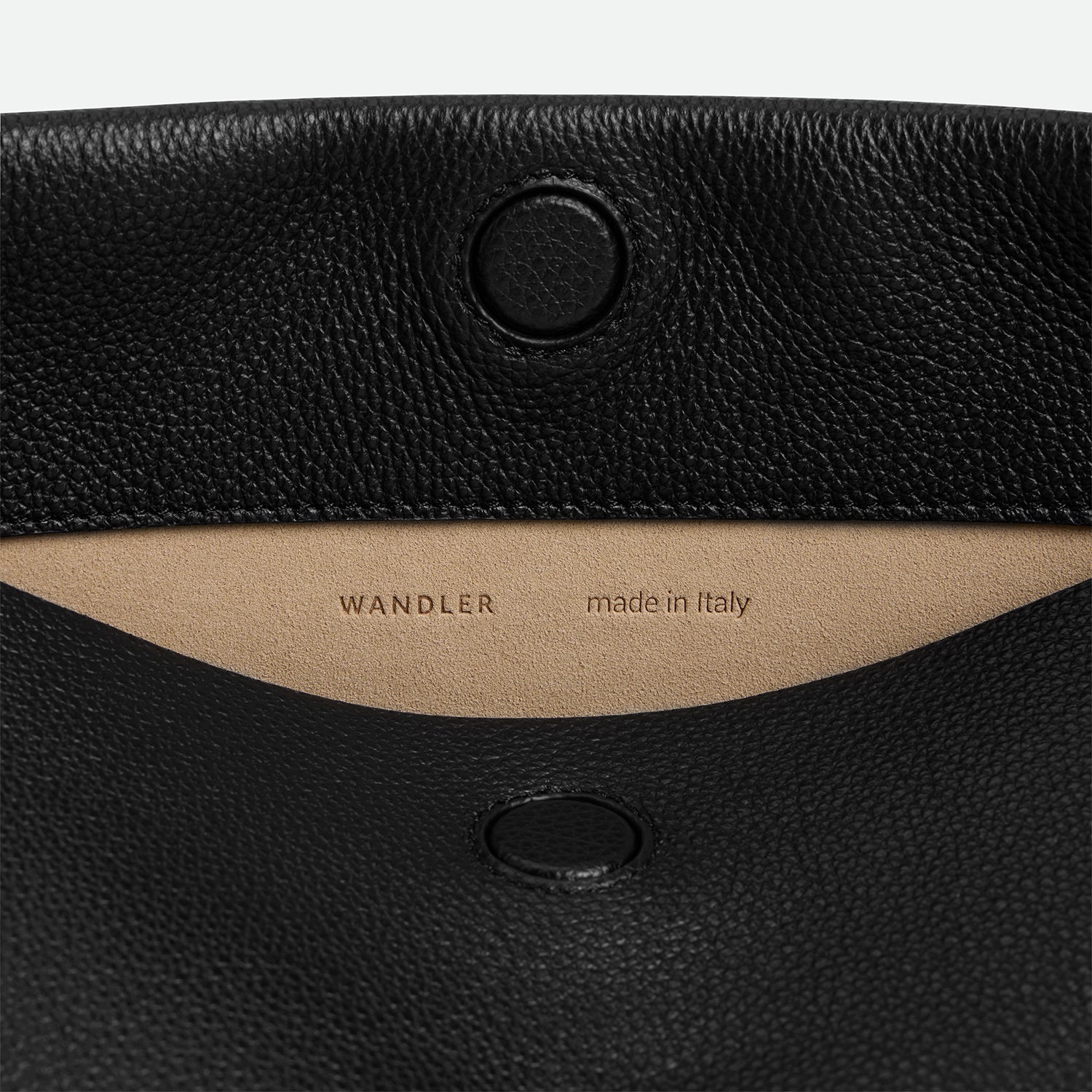 Wandler Penelope Tote Small in the color Black Crust made from calf leather with golden hardware and soft slouchy silhouette, close up detailing the closure and leather.