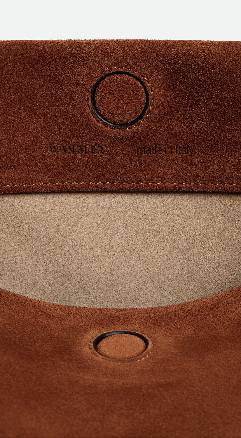 Wandler Penelope Tote Small in the color Saddle Suede calf leather with golden hardware and soft slouchy silhouette, close up picture detailing the logo and the leather.