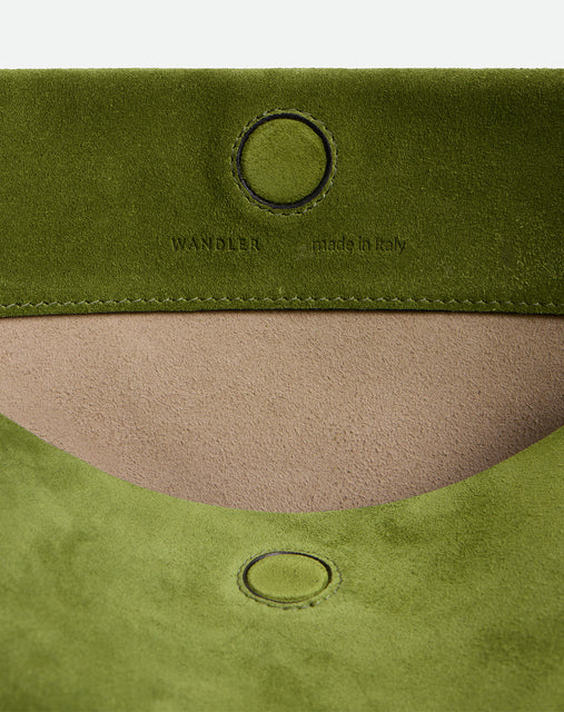 Wandler Penelope Tote Small in the color Verde Suede / Black made from calf leather with golden hardware and soft slouchy silhouette, close up detailing the closure and leather.