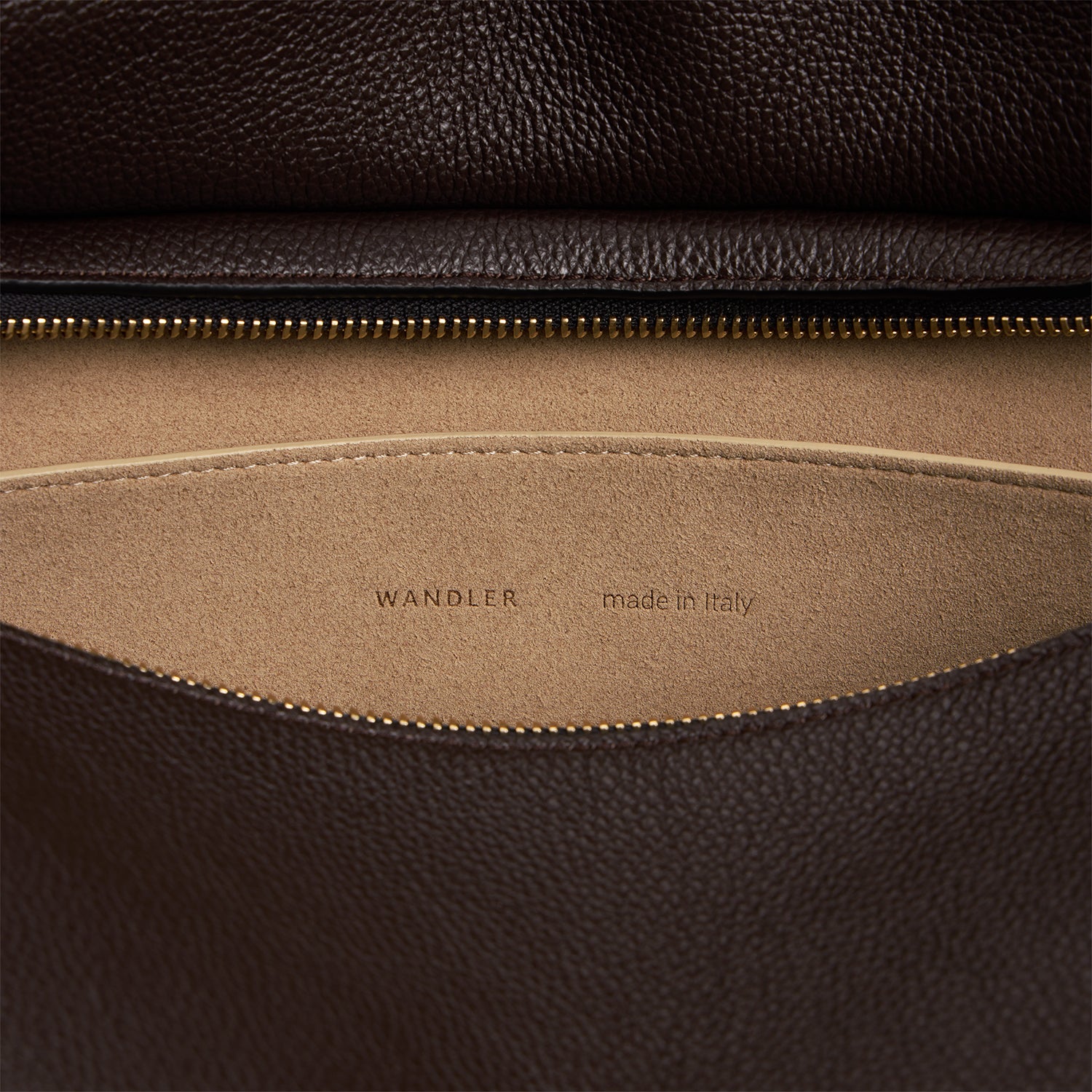 Wandler Penelope Tote in the color Soil Crust, made from Italian calf leather with golden hardware and soft structured silhouette, close up detailing the interior leather and logo.