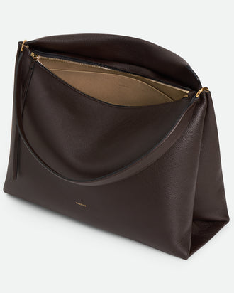 Wandler Penelope Tote in the color Soil Crust, made from Italian calf leather with golden hardware and soft structured silhouette, pictured from above with zipper open, giving a glimpse of the inside of the bag.