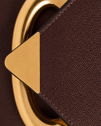 Wandler Veneto Crossbody Bag in Soil Caviar calf leather with oversized golden clasp hardware and structured silhouette, close up detailing the clasp.