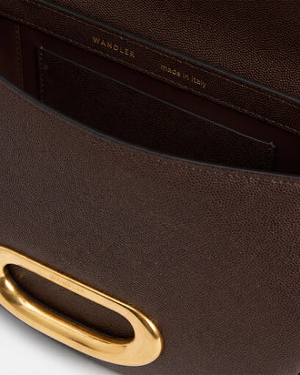 Wandler Veneto Crossbody Bag in Soil Caviar calf leather with oversized golden clasp hardware and structured silhouette, pictured from above with the flap open, giving a glimpse of the inside. 