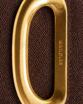 Wandler Veneto Crossbody Bag in Soil Caviar calf leather with oversized golden clasp hardware and structured silhouette, close up detailing the clasp, alternative picture. 