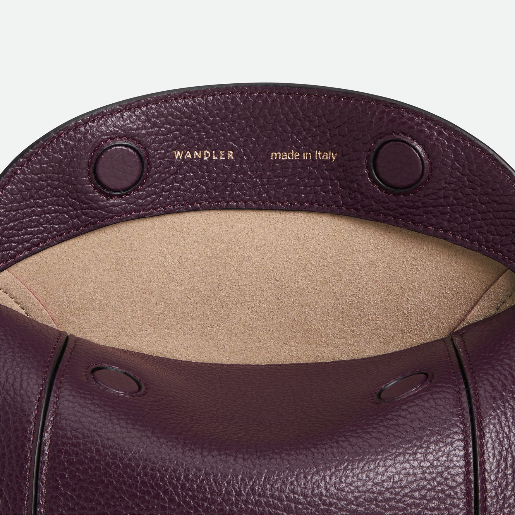 Wandler Penelope Slouch Bag in the color Aubergine Crust, made from calf leather with golden hardware and adjustable slim strap, close up detailing the closure and leather.