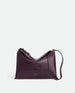 Wandler Penelope Slouch Bag in the color Aubergine Crust, made from calf leather with golden hardware and adjustable slim strap, front view.