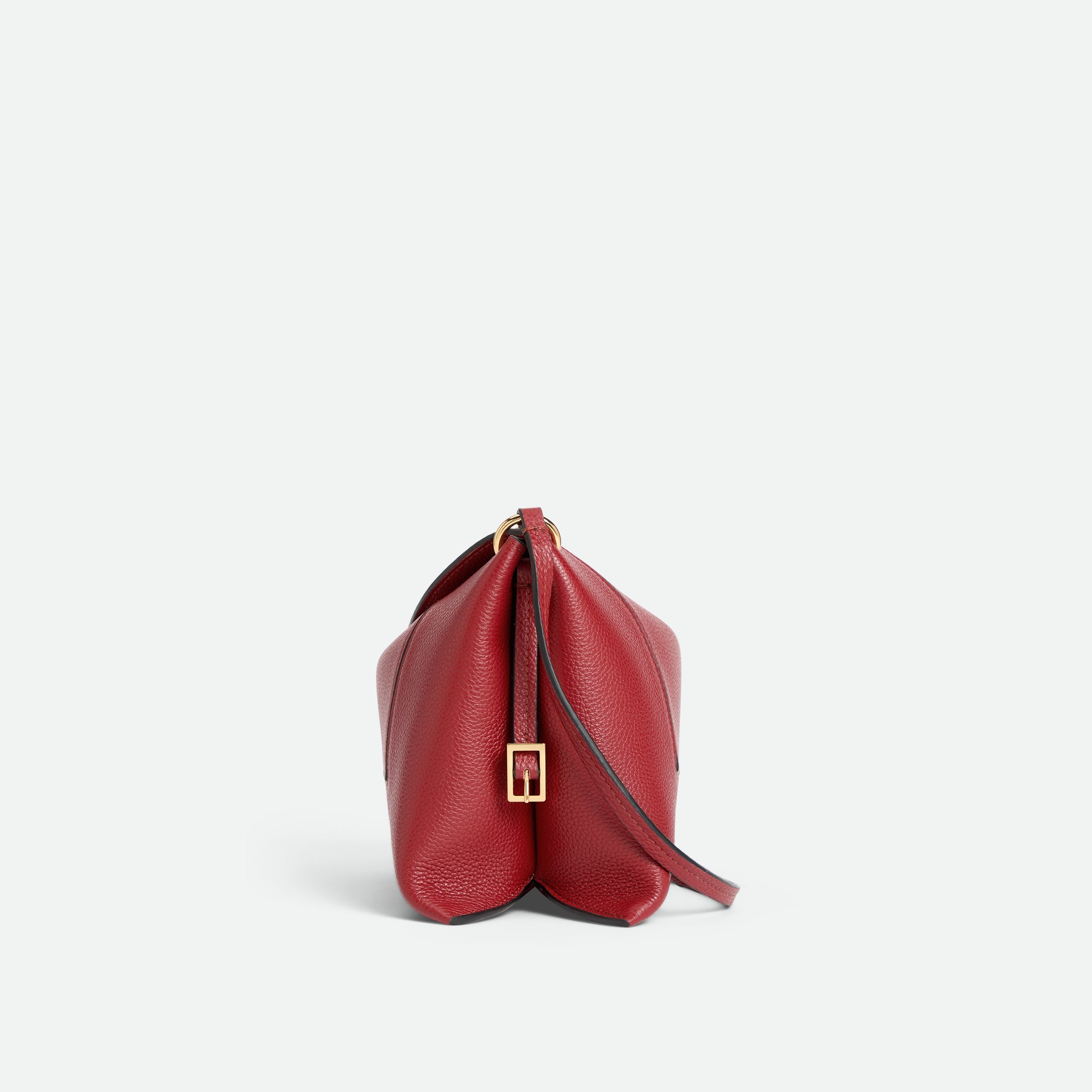 Wandler Penelope Slouch Bag in the color Scarlet Crust, made from calf leather with golden hardware and adjustable slim strap, side view.