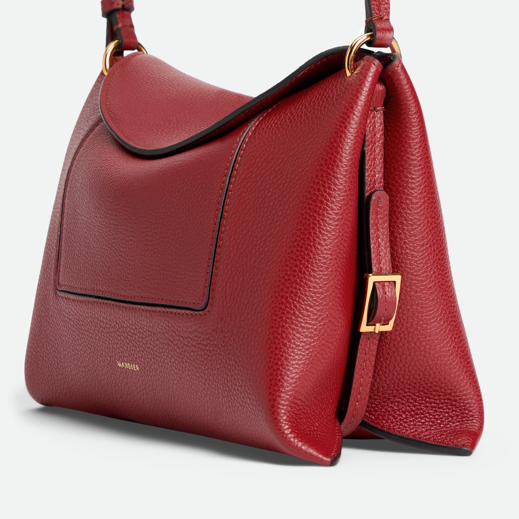 Wandler Penelope Slouch Bag in the color Scarlet Crust, made from calf leather with golden hardware and adjustable slim strap, side view.