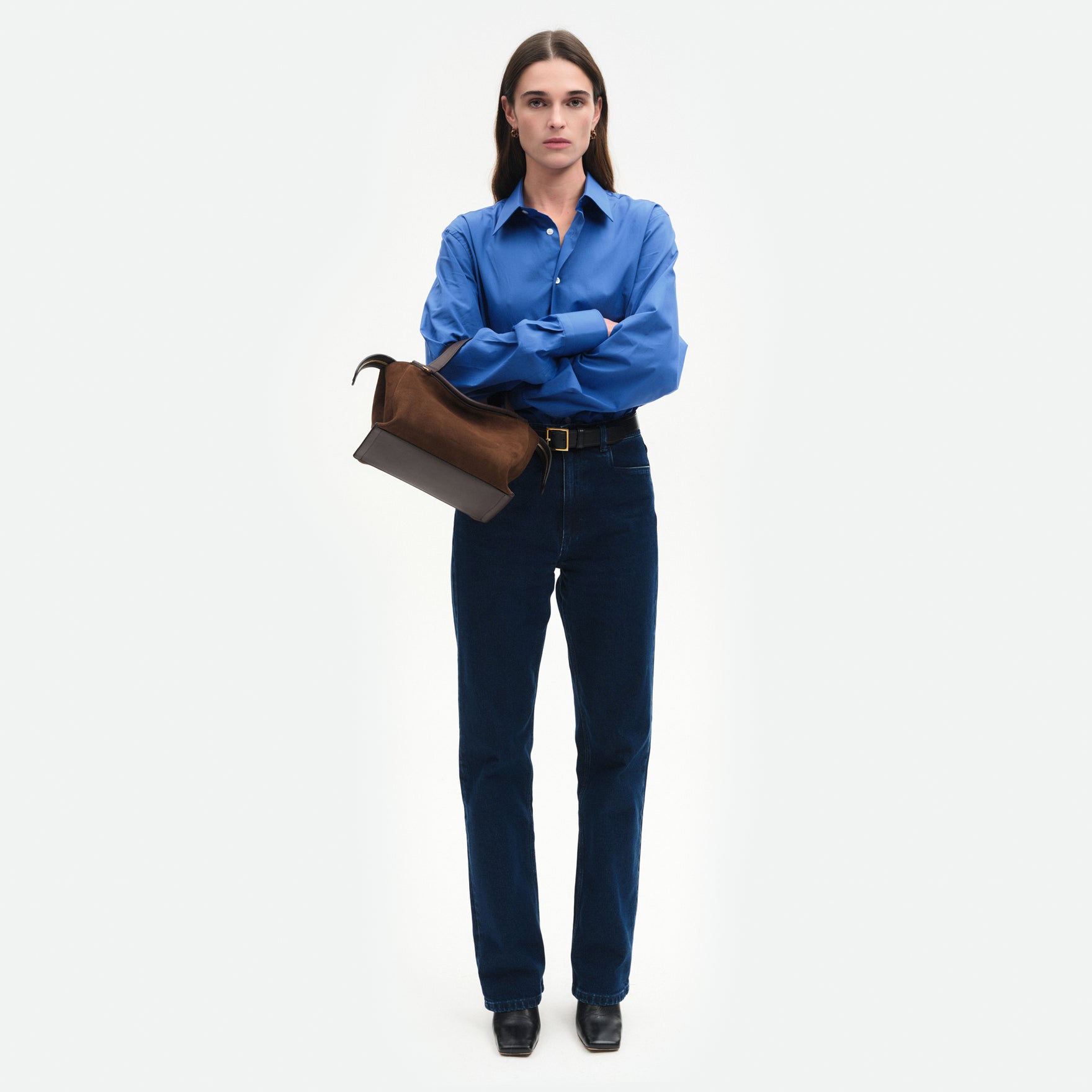 Wandler Ida Bag in Palissander Suede, deep dark brown with red undertones, Italian calf leather with golden hardware and sculptural top handle, pictured on model wearing the bag on the forearm, front view.