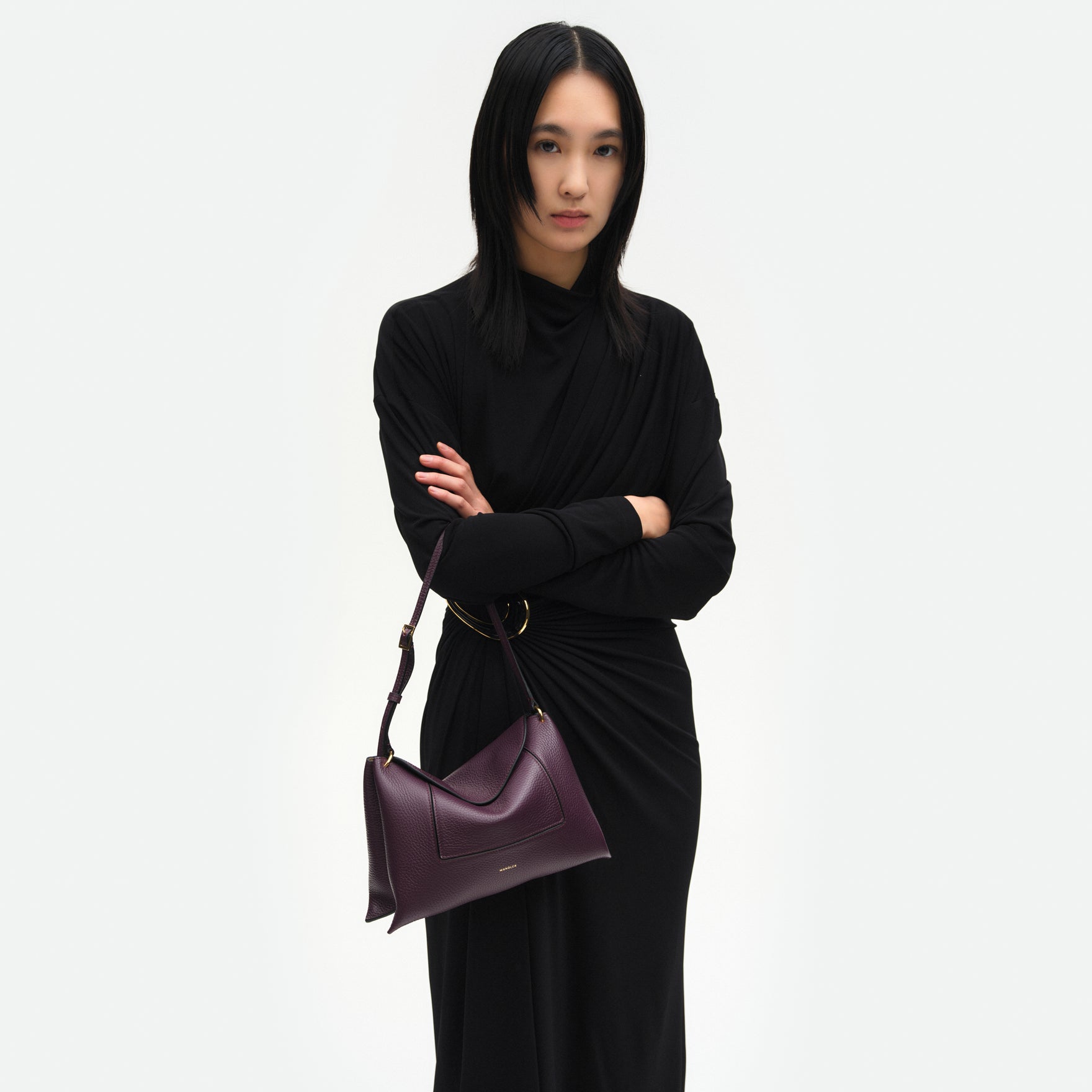Wandler Penelope Slouch Bag in the color Aubergine Crust, made from calf leather with golden hardware and adjustable slim strap, pictured being worn on the fore arm by model, half body picture.