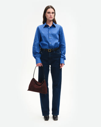 Wandler Penelope Tote Small in the color Acai Suede / Black made from calf leather with golden hardware and soft slouchy silhouette, pictured being handheld by model, full body picture.