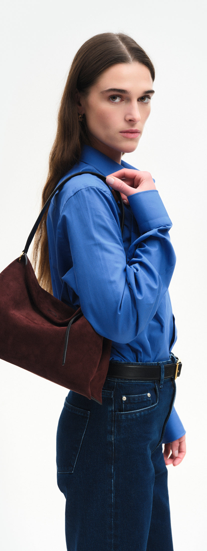 Wandler Penelope Tote Small in the color Acai Suede / Black made from calf leather with golden hardware and soft slouchy silhouette, pictured on model, being worn on the shoulder, half body picture.