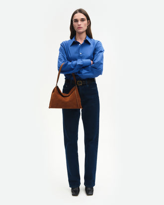 Wandler Penelope Tote Small in the color Saddle Suede calf leather with golden hardware and soft slouchy silhouette, worn on the forearm by model, full body picture.