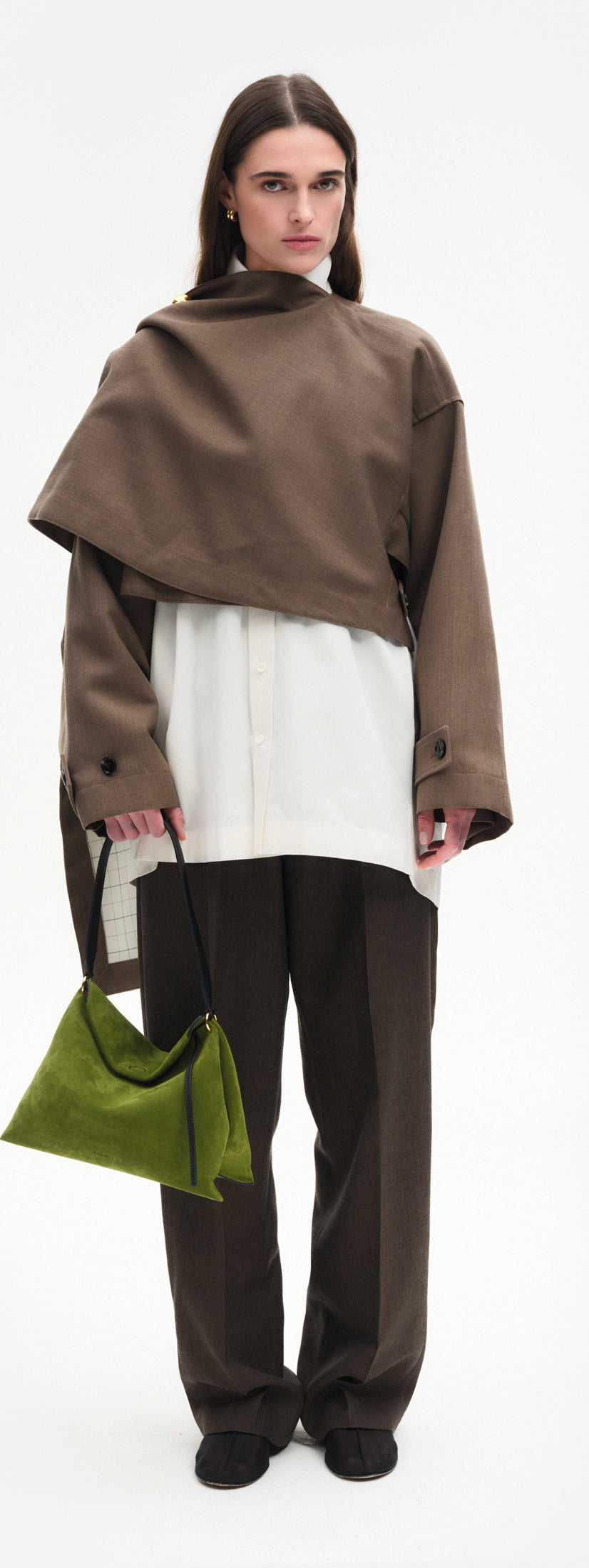 Wandler Penelope Tote Small in the color Verde Suede / Black made from calf leather with golden hardware and soft slouchy silhouette, pictured being hand carried by model, full body picture.