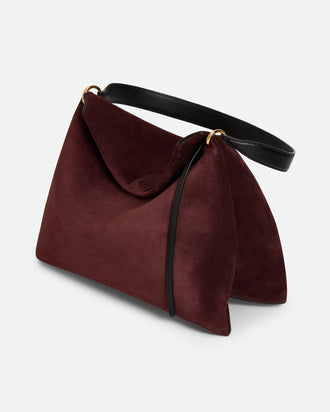 Wandler Penelope Tote Small in the color Acai Suede / Black made from calf leather with golden hardware and soft slouchy silhouette, three quarters view.