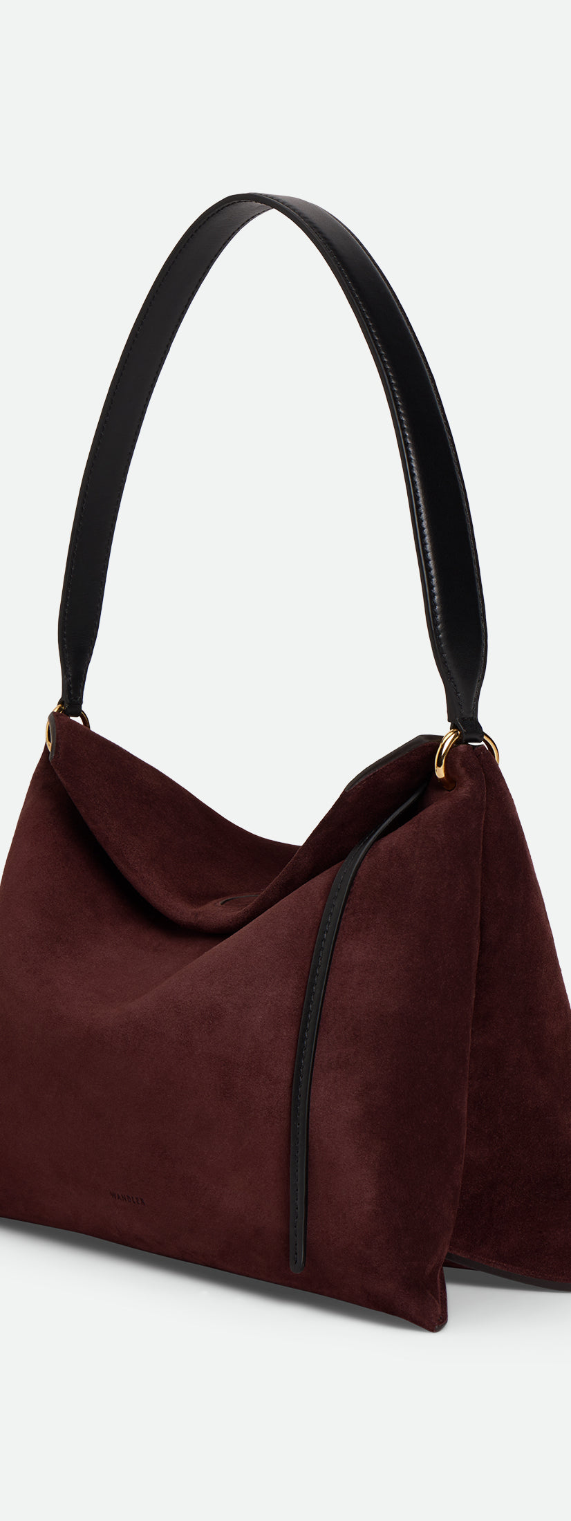 Wandler Penelope Tote Small in the color Acai Suede / Black made from calf leather with golden hardware and soft slouchy silhouette, three quarters view with the straps suspended into the air.