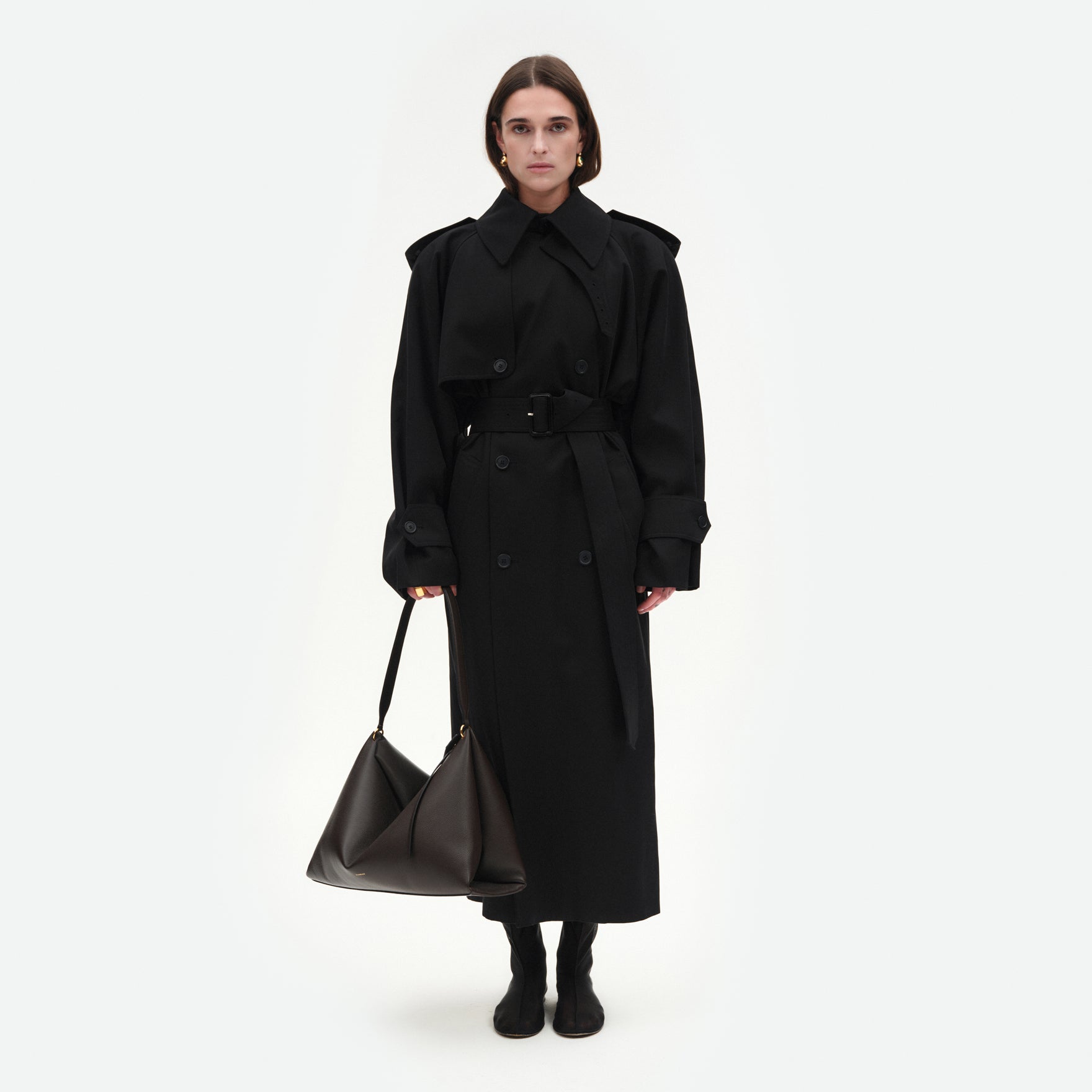 Wandler Penelope Tote in the color Soil Crust, made from Italian calf leather with golden hardware and soft structured silhouette, pictured being hand-held by model.