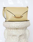 Wandler Veneto Shoulder Bag Small in the color Island, made from Italian calf leather with oversized golden clasp hardware, structured silhouette, pictured on pillar.