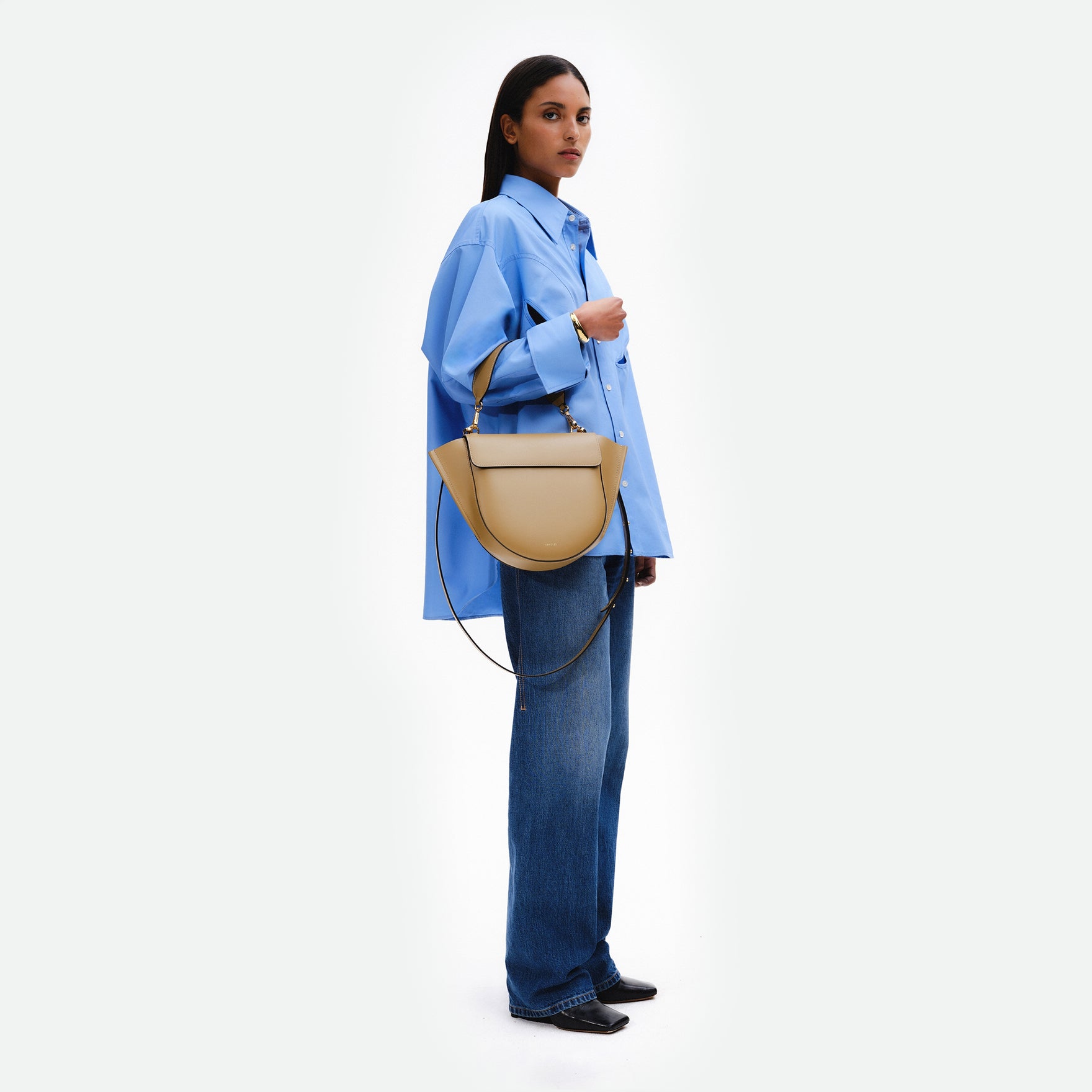 Wandler Hortensia Bag Medium in the color Gingerbread, dark beige, made from Italian calf leather with golden hardware, rounded silhouette and top handle, pictured being worn by model on the forearm. 