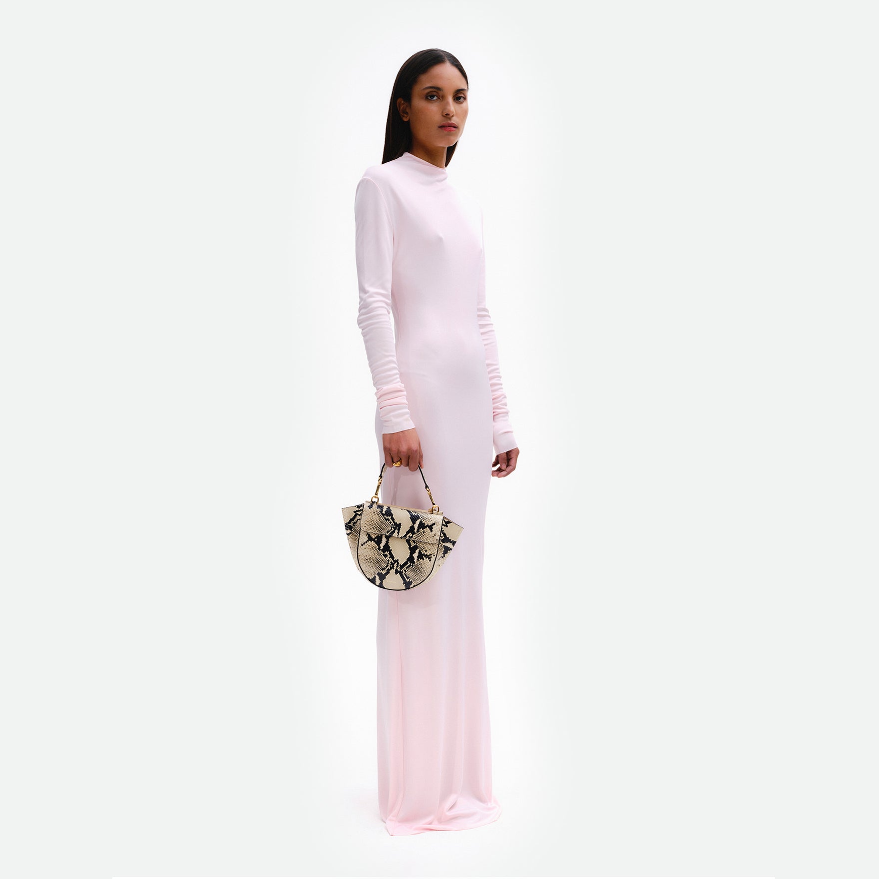 Wandler Hortensia Bag Mini in the color Black / White Python, Italian calf leather with golden hardware, rounded silhouette and top handle, pictured being hand-held by model. 