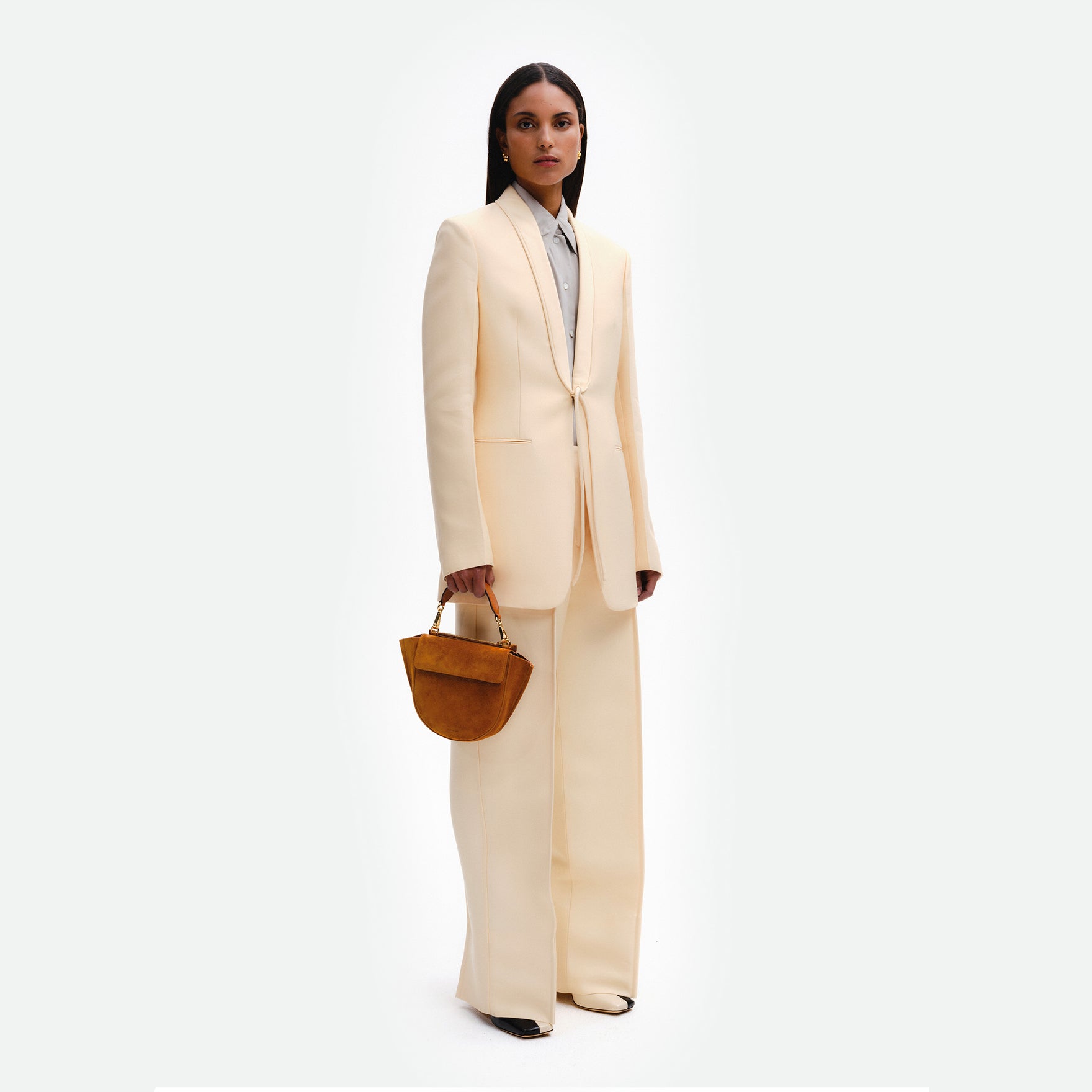 Wandler Hortensia Bag Mini in the color Cognac Suede, soft warm brown suede, Italian calf leather with golden hardware, rounded silhouette and top handle, pictured being hand-held by model. 
