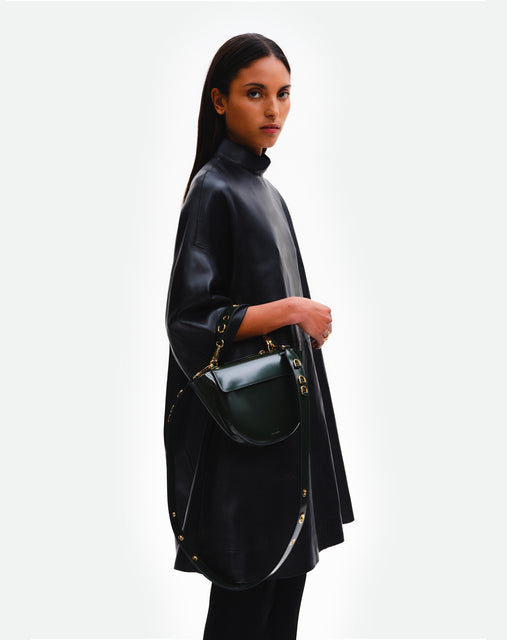Wandler Hortensia Bag Mini Eyelets in the color Jazz Olive, made from Italian calf leather with golden hardware and rounded silhouette, pictured being worn on the forearm by model.