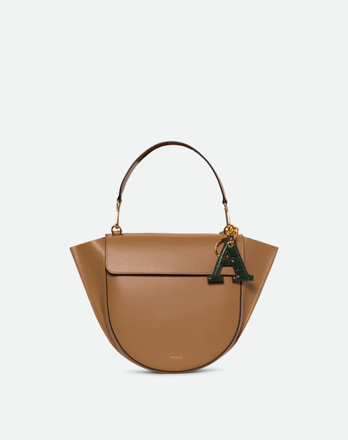 Wandler Bag Charm Letter in the color Olive Croco, green with crocodile print, Letter M, made from brass, lambskin leather with golden hardware, pictured being used a bag charm.
