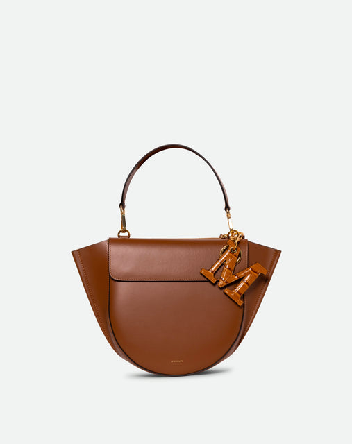 Wandler Bag Charm Letter in the color Saddle Croco, Warm brown with crocodile print, Letter M, made from brass, lambskin leather with golden hardware, pictured being used as a bag charm.