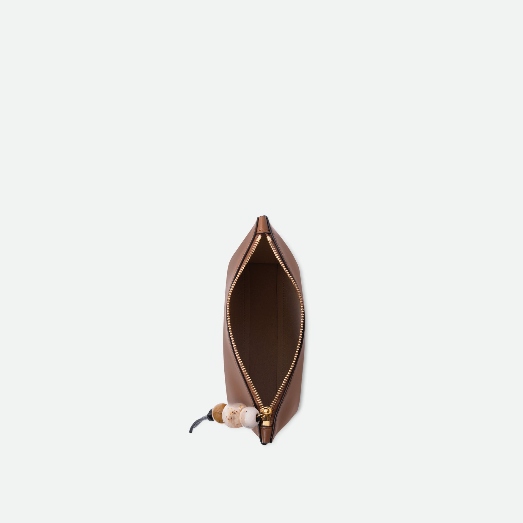 Wandler Ida Case in Saddle, made from calf leather with golden zipper hardware and charm, topside view with open zipper, inside of the bag is visible.