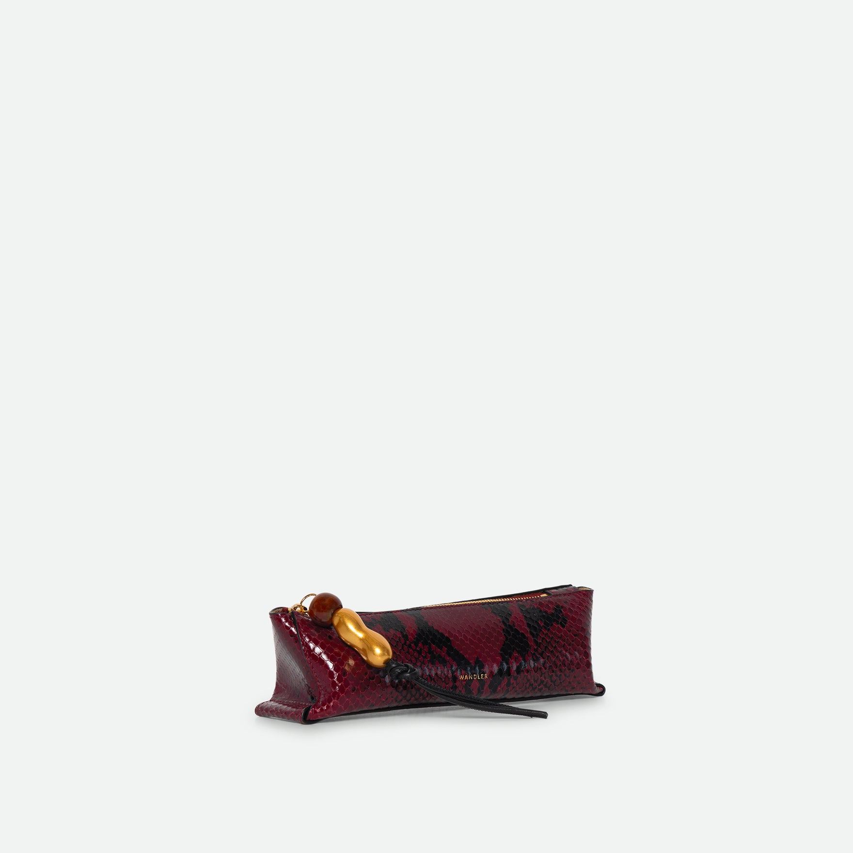 Wandler Ida Case Small in Bordeaux Python calf leather with golden zipper hardware and charm, three quarters view.