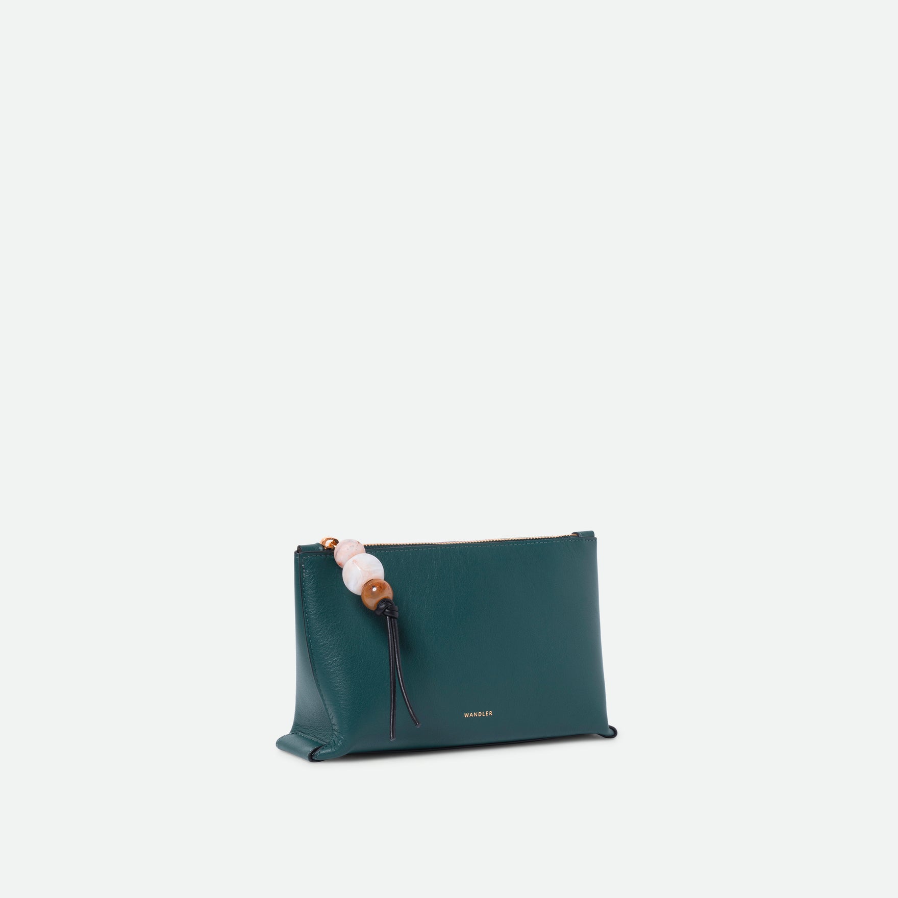 Wandler Ida Case in Teal made from calf leather with golden zipper hardware and charm, three quarters view.