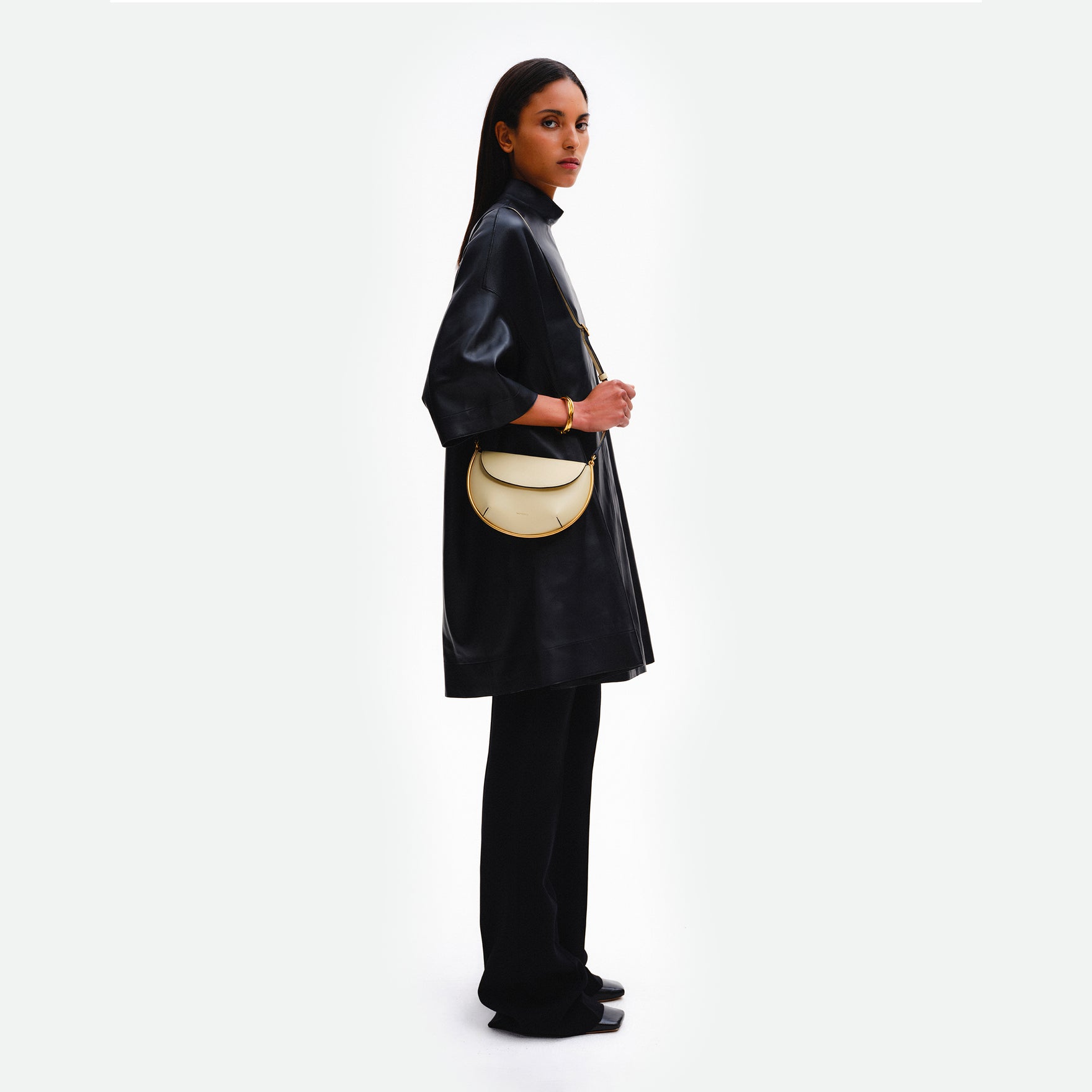 Wandler Kate Mini Crossbody in Helio Italian calf leather with golden hardware and adjustable strap, pictured on model, worn on the shoulder.