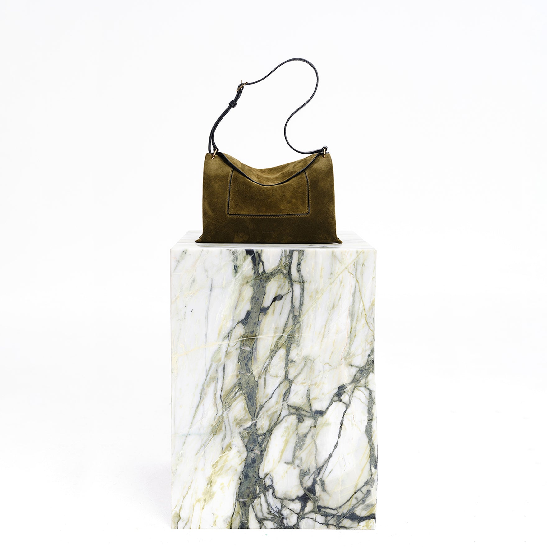 Wandler Penelope Slouch Bag in the color Orion Crust deep dark blue, made from calf leather with golden hardware and adjustable slim strap, bag pictured on pillar.