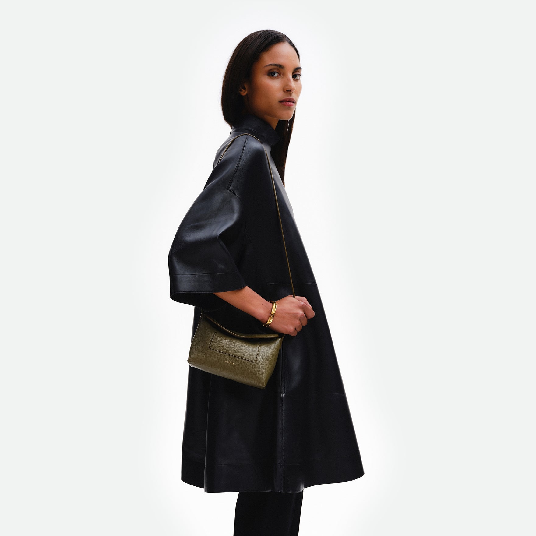 Wandler Penelope Slouch Mini in Olive Crust, green, Italian calf leather with golden hardware and slim adjustable strap, pictured on model worn on the shoulder.