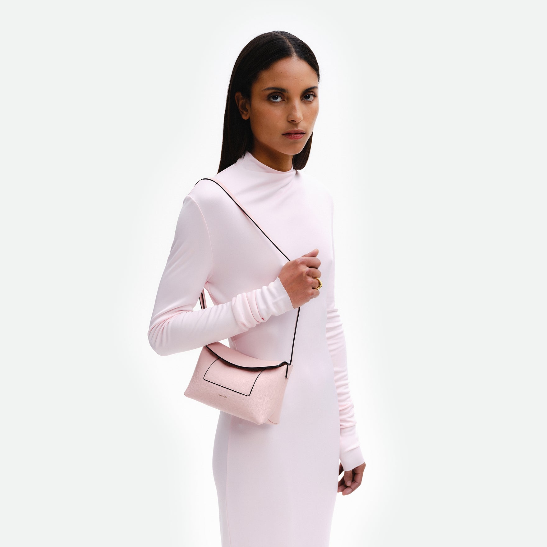 Wandler Penelope Slouch Mini in Rose Crust, pink, Italian calf leather with golden hardware and slim adjustable strap, pictured on model worn on the shoulder. 