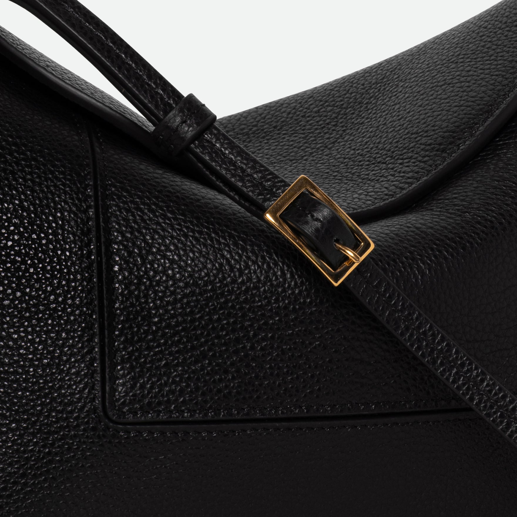 Wandler Penelope Slouch Bag in the color Black Crust, made from smooth calf leather with golden hardware and adjustable slim strap, close up detailing the clasp. 